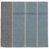 Detail of the Jasper Waffle Rug in Chalcedony, a large scale plaid pattern of denim blue, black, yellow and pale turqouise. 