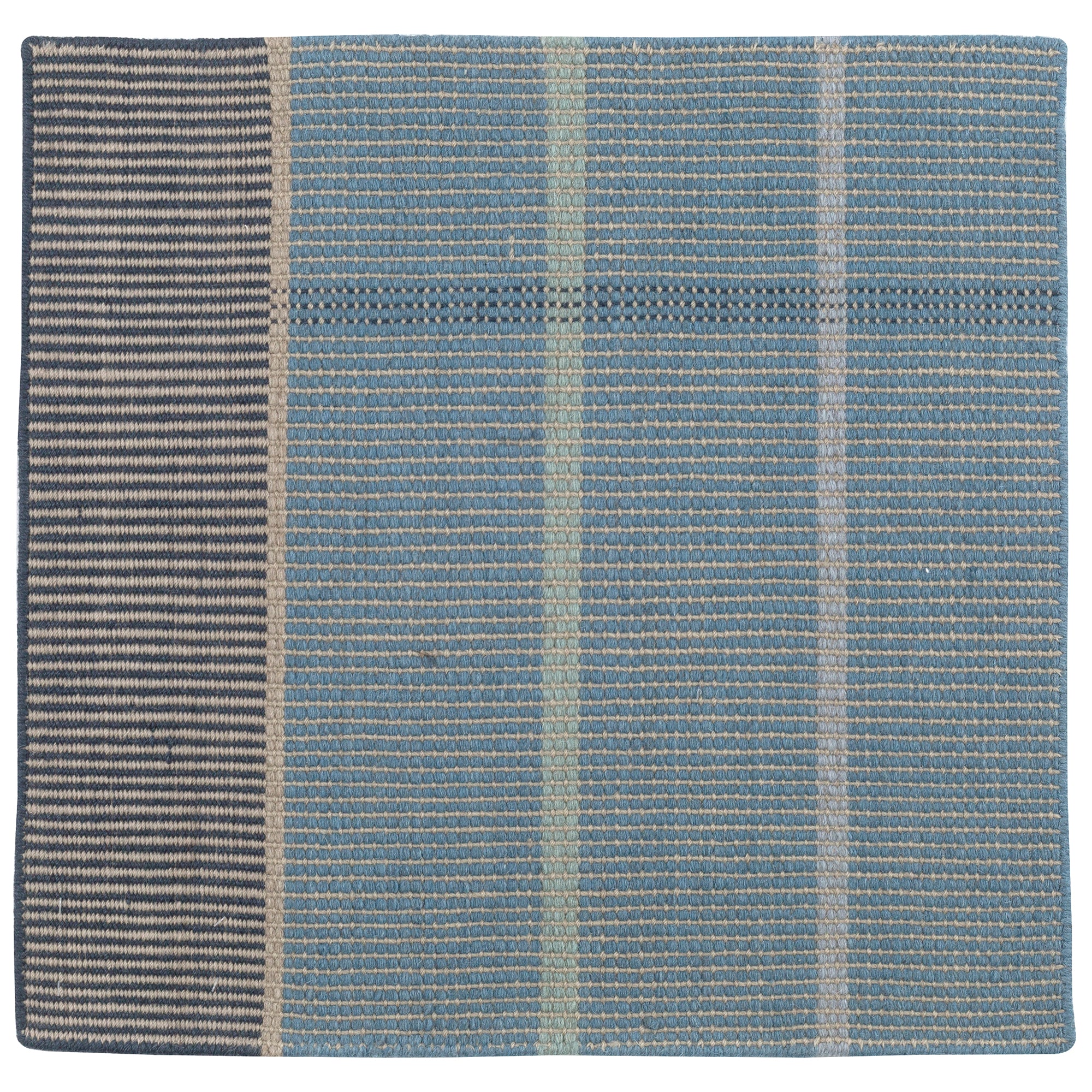 Detail of the Jasper Waffle Rug in Chalcedony, a large scale plaid pattern of denim blue, black, yellow and pale turqouise. 