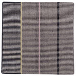 Detail of the Jasper Waffle Rug in Jet, widely spaced thin stripes of yellow, pink, black, acqua and white on a grey field. 