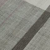 Detail of the Jasper Waffle Rug in Red Fossile, widely spaced stripes of yellow, pink, red, white and black on a split light grey fand ivory field. 