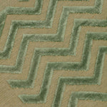Detail of the Penta Chevron Rug in Pale Jade a light green chevron pattern on a lime green  field with a wide solid border. 