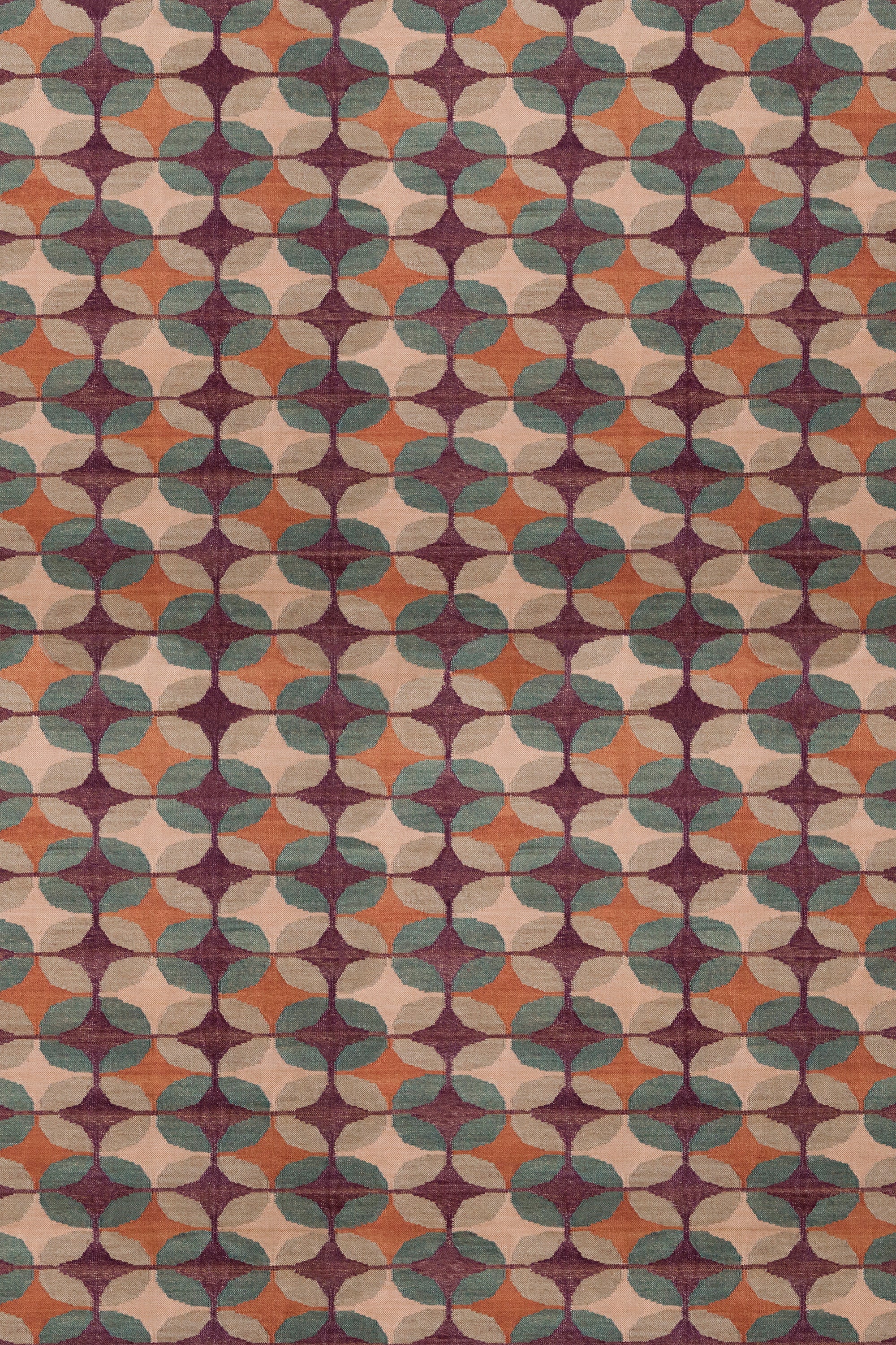 Petite Alhambra Rug featuring a pattern of linked circles that create a star like lattice in coral, taupe, turquoise and royal purple. 