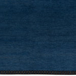 Detail of the Plain Stitched Border Rug in Prussian Blue, a solid indigo rug with a black border with black border with blue and taupe dashes. 
