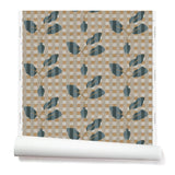 Wallpaper roll with a complex chambray and petrol blue floral motif overlayed a white and tan plaid pattern. 