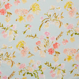 Linen swatch with a pattern of large-scale line-drawn flowers in gray ink with red, pink and yellow watercolors, on a light blue background.