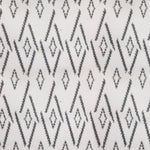 Woven broadloom carpet swatch in a repeating irregular diamond pattern in charcoal on a cream field.