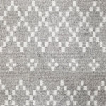 Wool broadloom carpet swatch in a repeating diamond print in white on a light gray field.