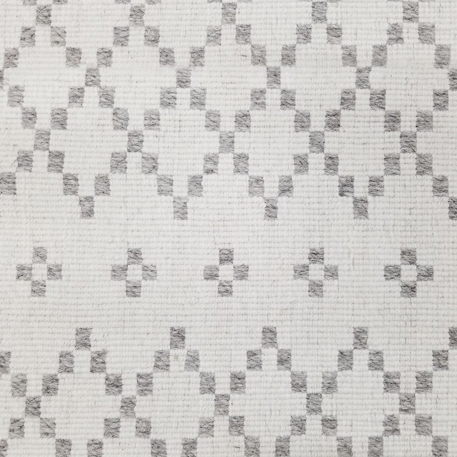 Wool broadloom carpet swatch in a repeating diamond print in light gray on an ivory field.