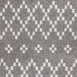 Wool broadloom carpet swatch in a repeating diamond print in light gray on a brown field.