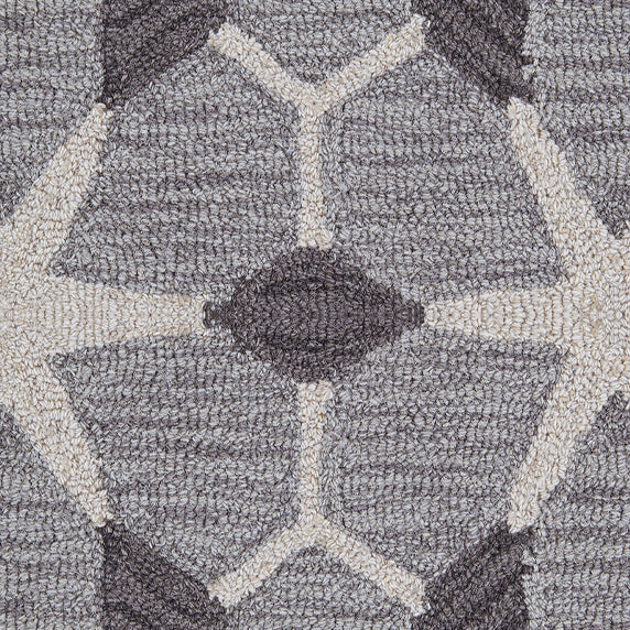 Detail of a wool broadloom carpet swatch in a geometric lattice pattern in cream and charcoal on a gray field.