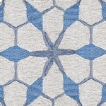 Wool broadloom carpet swatch in a geometric lattice pattern in shades of blue on a cream field.