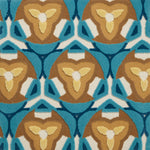 Detail of Gigi Rug featuring a geometric floral motif with a mix of cut pile and linear loops in tan, yellow, ivory and shades of blue
