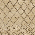 Woven rug swatch in a large-scale diamond pattern that transitions to a smaller-scale diamond pattern in black lines on a tan field.