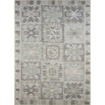 Large rectangular rug in a repeating abstract geometric pattern with a border of jagged geometric shapes, all in shades of gray.