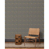 Wood and woven chair, brown stool and rug in front of wallpaper with a pattern of vertical stripes of light tan, dark olive green and dashes of cobalt blue and white, hover