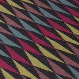 Detail of the Trio Rug in Jewel, a stacked triangle pattern with black, ruby red, blue, heather purple and yellow. 