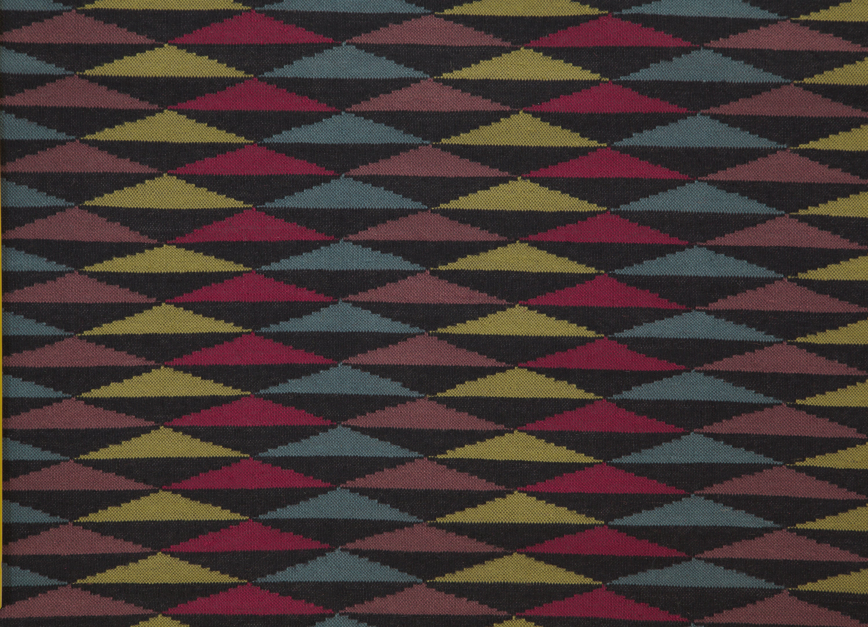 Detail of the Trio Rug in Jewel, a stacked triangle pattern with black, ruby red, blue, heather purple and yellow. 