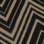 Detail of the Vertical Zig-Zag Rug in Onyx-Sandstone, a zig zag pattern in mixed widths in black and taupe.