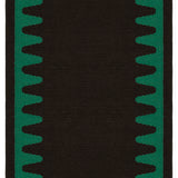 Detail of the Waver Rug in Modernist Green, a solid black field with a green flame stitch border. 