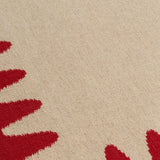 Detail of the Waver Rug in Pillbox Red, a solid Ivory field with a red flame stitch border. 