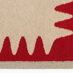 Detail of the Waver Rug in Pillbox Red, a solid Ivory field with a red flame stitch border. 