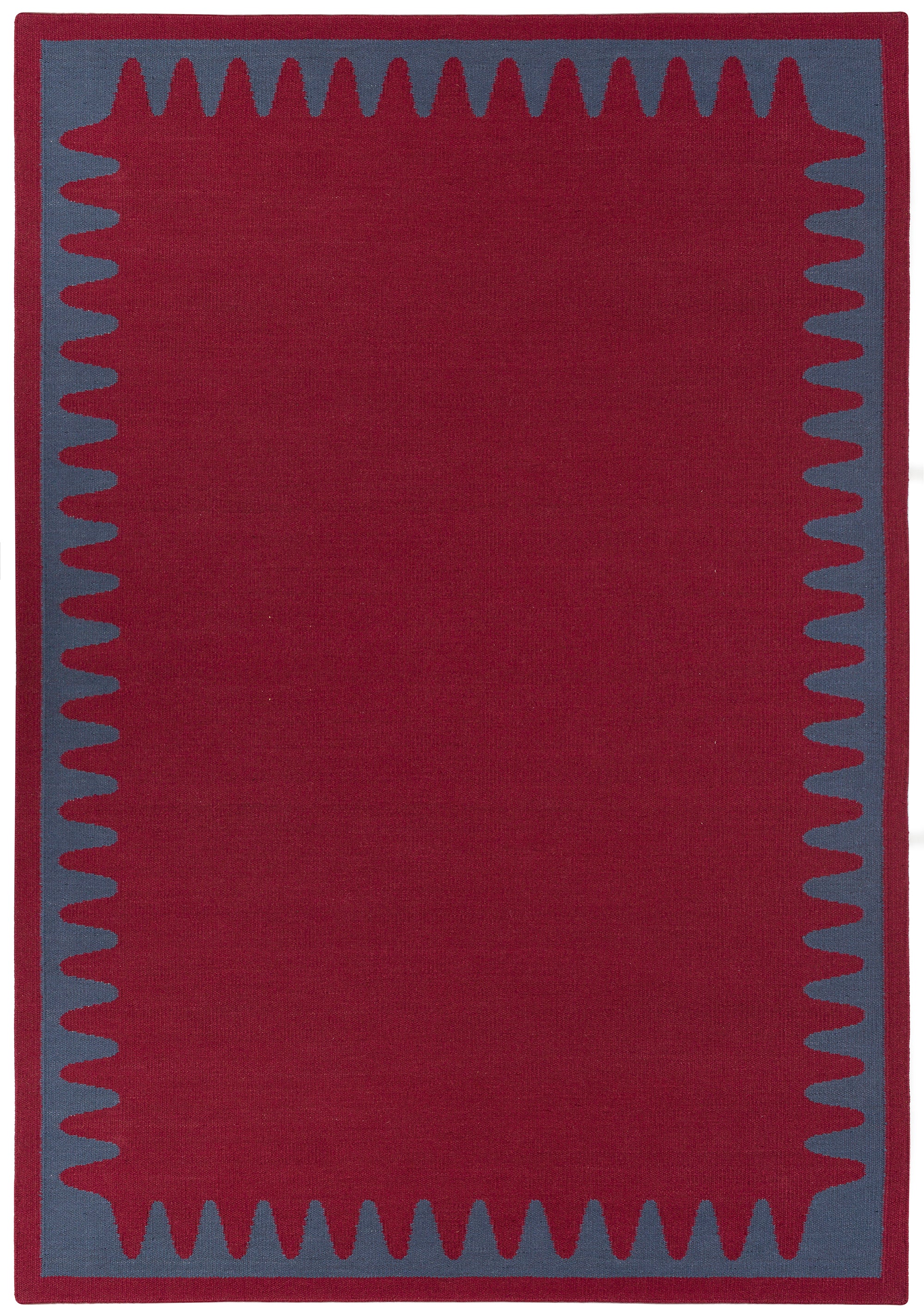 Waver Rug in Queensdown Red, a solid red field with a blue flame stitch border. 