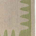 Detail of the Waver Rug in Sage, a strated taupe field with a sage green flame stitch border. 