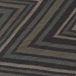 Detail of To The Point Rug in Pyrite-Metallic, a zig zag pattern in dark greens, metallic ecru and black.