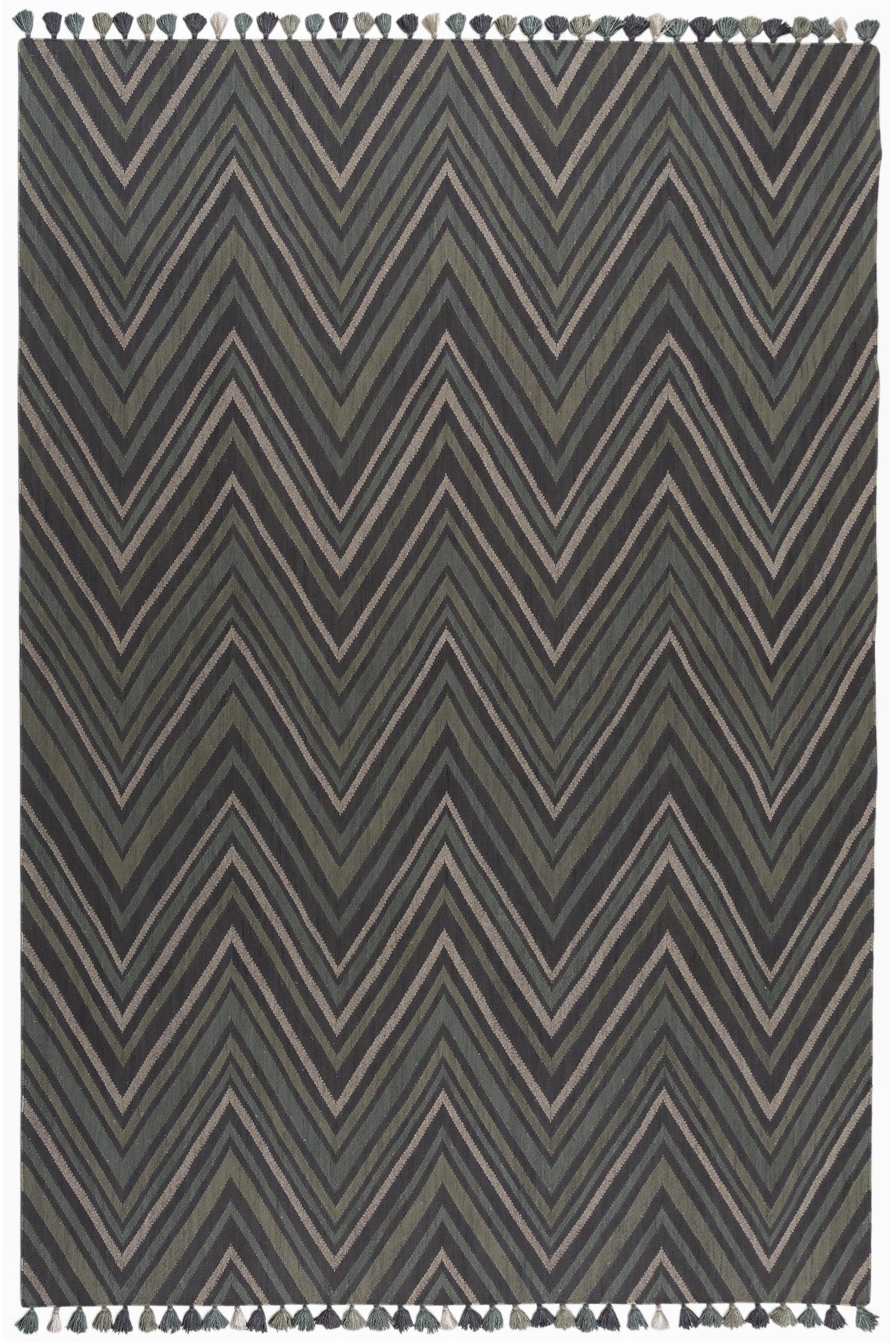 Full size To The Point Rug in Pyrite-Metallic, a zig zag pattern in dark greens, metallic ecru and black, with a mulit color tasseled edge. 