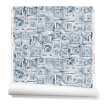 Partially unrolled wallpaper in a dense hand-drawn geometric motif in shades of navy on a white background.