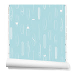 A roll of wallpaper with a pattern of illustrated surfboards in white on a light blue background.
