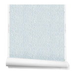 A hanging roll of wallpaper with a large-scale repeating leaf print in white on a light blue watercolor background.