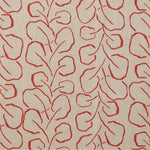 Woven fabric swatch with a large-scale repeating leaf print in red on a tan background.