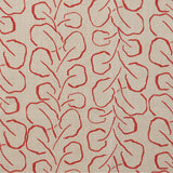 Woven fabric swatch with a large-scale repeating leaf print in red on a tan background.